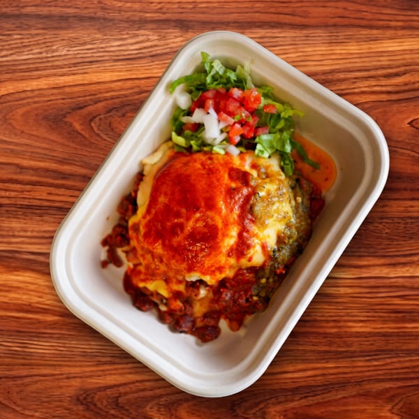 Hearty baked dish with melted cheese and red sauce, topped with fresh salsa and lettuce.